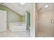 Bright bathroom featuring a soaking tub, step-in shower, tile floors, and a neutral color palette at 13636 Lake Point S Dr, Clearwater, FL 33762
