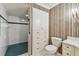 Full bathroom with tiled shower, cabinet storage, and decorative wallpaper accents at 13636 Lake Point S Dr, Clearwater, FL 33762
