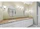 Bathroom featuring double vanity with granite countertop, undermount sinks, and decorative lighting at 13636 Lake Point S Dr, Clearwater, FL 33762