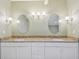 Bathroom featuring a double vanity with granite countertop and decorative lighting at 13636 Lake Point S Dr, Clearwater, FL 33762