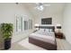 Comfortable bedroom features a large window, ceiling fan and mounted television at 13636 Lake Point S Dr, Clearwater, FL 33762
