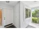 A bright entryway featuring a white front door, tiled flooring, and a view of the screened-in porch at 13636 Lake Point S Dr, Clearwater, FL 33762