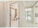Hallway view showcasing tile flooring, neutral paint, and an adjacent bathroom and open living space at 13636 Lake Point S Dr, Clearwater, FL 33762
