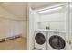 Well-lit laundry room with modern washer and dryer and wire shelving in the closet at 13636 Lake Point S Dr, Clearwater, FL 33762