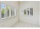 Bright living area features white tile floors and multiple shuttered windows at 13636 Lake Point S Dr, Clearwater, FL 33762