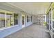 Covered and screened porch featuring tile floors and access to the yard at 13636 Lake Point S Dr, Clearwater, FL 33762