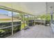 Well lit screened porch with tile flooring and views of the landscaped backyard at 13636 Lake Point S Dr, Clearwater, FL 33762