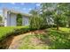 Landscaped side yard featuring a lush lawn and mature trees at 13636 Lake Point S Dr, Clearwater, FL 33762