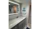 Modern bathroom vanity with sleek countertop, framed mirror, and stylish gray cabinetry at 1380 Gulf Blvd # 805, Clearwater, FL 33767