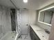 Modern bathroom with white marble-look tile, shower-tub combination, and illuminated mirror at 1380 Gulf Blvd # 805, Clearwater, FL 33767