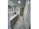 Modern bathroom with gray cabinets, double sink, lighted mirror, and glass shower at 1380 Gulf Blvd # 805, Clearwater, FL 33767
