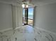 Bright bedroom with balcony access offering ocean views and marble-look tile flooring at 1380 Gulf Blvd # 805, Clearwater, FL 33767