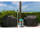 Outdoor grilling area with two grills, an outdoor light and lush vegetation offering a perfect space for entertaining at 1380 Gulf Blvd # 805, Clearwater, FL 33767