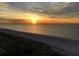 Breathtaking sunset view over the ocean, with a golden sky reflecting on the calm waters and sandy beach at 1380 Gulf Blvd # 805, Clearwater, FL 33767