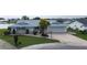 Aerial view of a lovely single-Gathering home with a well-kept lawn and a driveway leading to an attached garage at 1407 Brattleboro Cir, Sun City Center, FL 33573