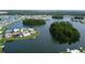 Panoramic aerial view of a home with backyard dock and canal access; mature trees and manicured lawn at 1407 Brattleboro Cir, Sun City Center, FL 33573