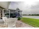 Expansive backyard featuring a screened-in patio, lush lawn, and waterfront access at 1407 Brattleboro Cir, Sun City Center, FL 33573