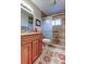 Modern bathroom with a stone-tiled shower and vanity with ample storage at 1407 Brattleboro Cir, Sun City Center, FL 33573