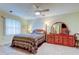 Bedroom featuring a comfortable bed with patterned bedding, a dresser, and a ceiling fan at 1407 Brattleboro Cir, Sun City Center, FL 33573