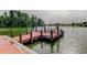 A red, wooden dock extends into a lake, ideal for boating and enjoying the serene water views at 1407 Brattleboro Cir, Sun City Center, FL 33573