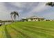 Lush green lawn leading up to a waterfront home with a private dock and beautiful lake views at 1407 Brattleboro Cir, Sun City Center, FL 33573