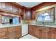 This charming kitchen features wood cabinets, tile floors, and modern white appliances at 1407 Brattleboro Cir, Sun City Center, FL 33573