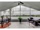 Enclosed lanai featuring a ceiling fan, tiled floor, and views of the water at 1407 Brattleboro Cir, Sun City Center, FL 33573