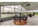 Screened lanai with a dining table, ceiling fan, and expansive lake views at 1407 Brattleboro Cir, Sun City Center, FL 33573