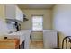 This laundry room features a utility sink, washing machine, dryer, and cabinet storage above at 1407 Brattleboro Cir, Sun City Center, FL 33573