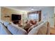 Cozy living room with hardwood floors, a large sectional, and a ceiling fan at 1407 Brattleboro Cir, Sun City Center, FL 33573