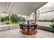 Enclosed patio featuring tile floors, outdoor dining set, and serene lake views at 1407 Brattleboro Cir, Sun City Center, FL 33573