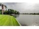 Scenic waterfront view featuring a well-manicured lawn, private boat dock, and tranquil waters at 1407 Brattleboro Cir, Sun City Center, FL 33573