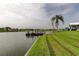 Picturesque waterfront with lush grass, a private boat dock, and calm water views at 1407 Brattleboro Cir, Sun City Center, FL 33573