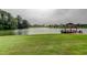 Calm waterfront view showcasing a lush lawn, lake access, and surrounding neighborhood homes at 1407 Brattleboro Cir, Sun City Center, FL 33573