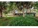 A vibrant backyard with beautiful plantings and a large shady tree at 152 58Th S Ave, St Petersburg, FL 33705