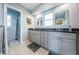 Bathroom with double vanity, modern countertops, and a door leading to a tiled walk-in shower at 152 58Th S Ave, St Petersburg, FL 33705