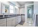 Bathroom featuring double sinks with a gray vanity, modern mirrors, and a tiled shower stall at 152 58Th S Ave, St Petersburg, FL 33705