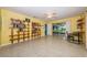 Sunny bedroom with built-in bookshelves, terrazzo floors, and a view of the landscaped backyard at 152 58Th S Ave, St Petersburg, FL 33705