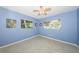 Bright bedroom with blue walls, terrazzo floors, and two windows offering natural light at 152 58Th S Ave, St Petersburg, FL 33705