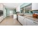 Well-lit kitchen featuring granite countertops, white cabinetry, and stainless-steel dishwasher at 152 58Th S Ave, St Petersburg, FL 33705