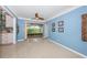 Cozy living room featuring light blue walls, terrazzo floors, and sliding glass doors to the backyard at 152 58Th S Ave, St Petersburg, FL 33705