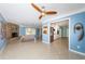 Spacious living room with a stone fireplace, modern ceiling fan, and views into the kitchen at 152 58Th S Ave, St Petersburg, FL 33705