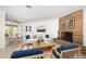 Staged living room with a stone fireplace, neutral furniture, and large windows at 152 58Th S Ave, St Petersburg, FL 33705