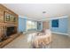 Cozy living room features a stone fireplace, large windows, and terrazzo flooring at 152 58Th S Ave, St Petersburg, FL 33705