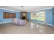Bright living room with a stone fireplace, large window, and terrazzo flooring at 152 58Th S Ave, St Petersburg, FL 33705