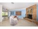 Inviting living room boasts a stone fireplace, terrazzo floors, and sliding glass doors to the lanai at 152 58Th S Ave, St Petersburg, FL 33705