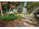 A landscaped side yard featuring mature palms and a lush garden at 152 58Th S Ave, St Petersburg, FL 33705