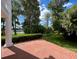 Brick patio with lush trees and landscaping, complemented by a serene lake view at 15612 Howell Park Ln, Tampa, FL 33625
