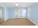 A bedroom with light blue walls, mirrored closet, and glass doors at 15612 Howell Park Ln, Tampa, FL 33625