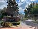 Elegant community entrance featuring a brick sign and well-manicured landscaping at 15612 Howell Park Ln, Tampa, FL 33625
